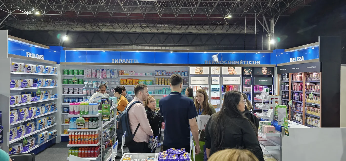 Espaço Farmácia Modelo montado no salão, com gôndolas de dermocosméticos e infantil